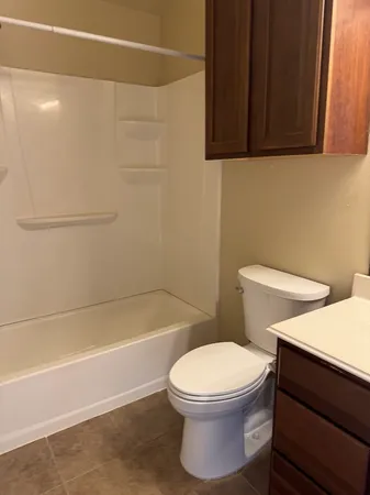 a white toilet sitting next to a bath tub