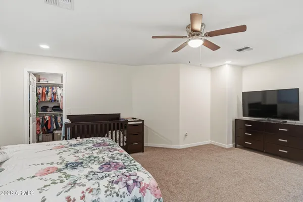 a bedroom with a bed and dresser with chair