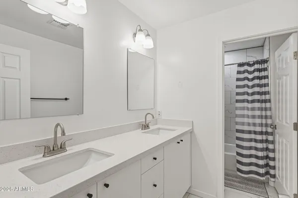 a bathroom with a sink vanity mirror and shower
