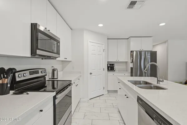 a kitchen with a sink a table and chairs
