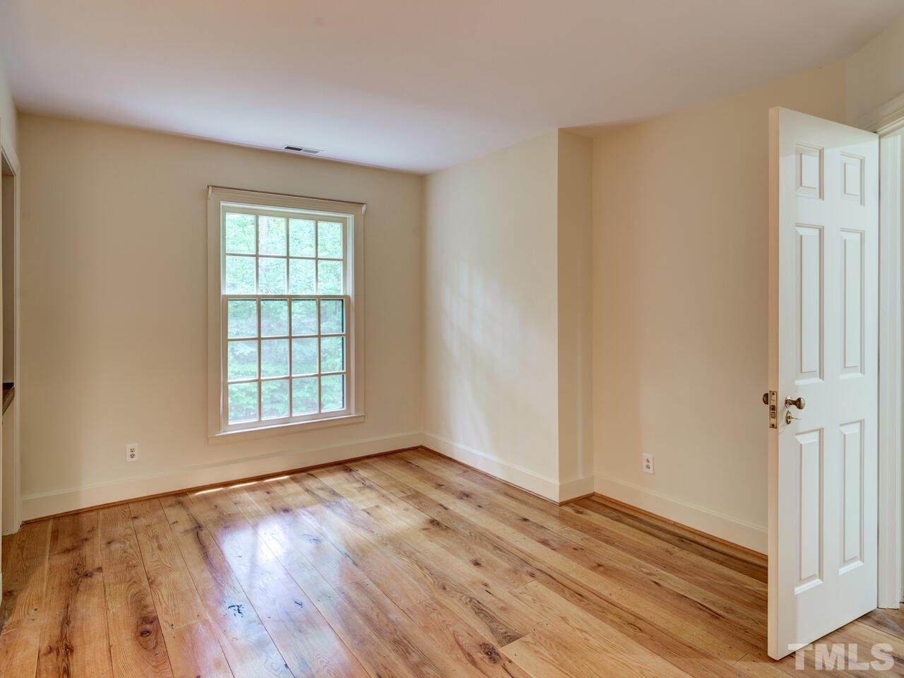 1100 Trail End Road Durham, NC 27712 - Photo 22 of 30 an empty room with wooden floor and windows
