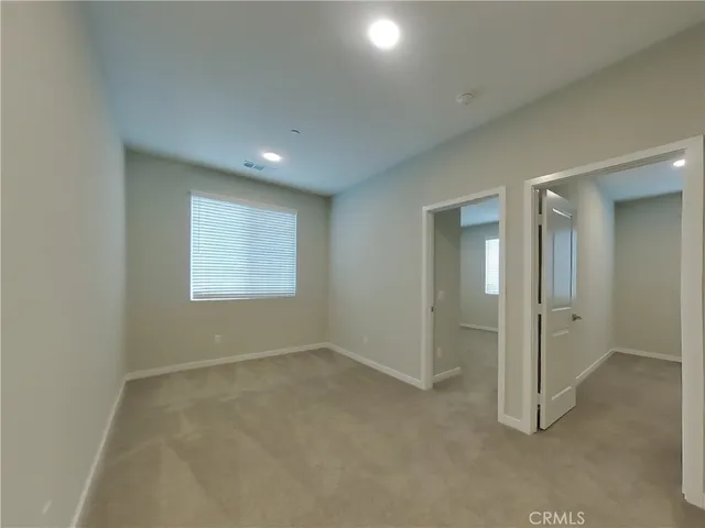 an empty room with windows and closet