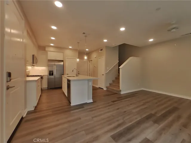 a view of kitchen with kitchen island wooden floors appliances and center island