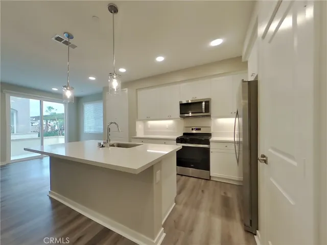 a kitchen with stainless steel appliances granite countertop a sink a stove and a refrigerator