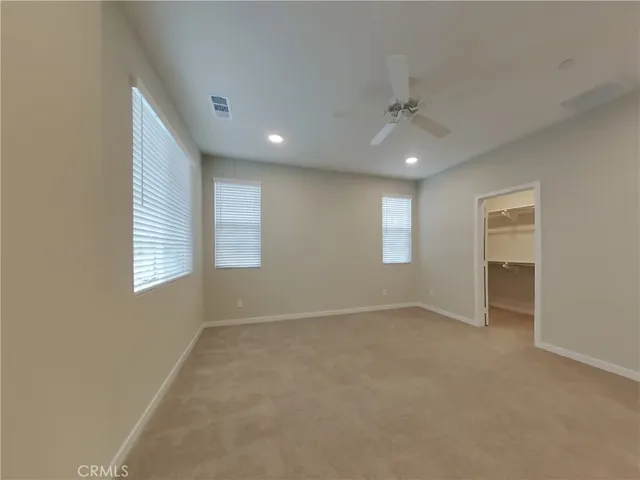 an empty room with windows and closet