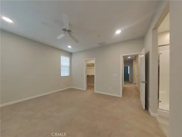 an empty room with fan and windows