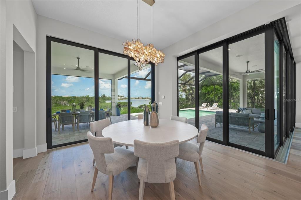 1109 Bayshore Road Nokomis, FL 34275 - Photo 13 of 63 a view of a dining room with furniture large windows and wooden floor