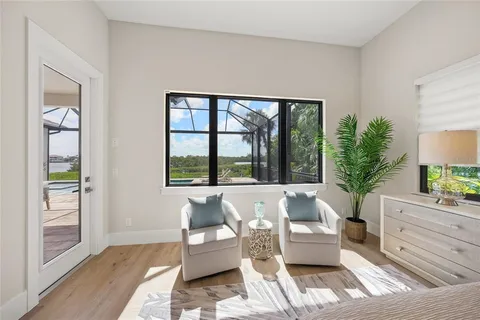 a bedroom with a bed and large windows