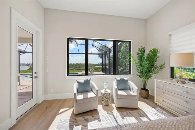 a bedroom with a bed and large windows