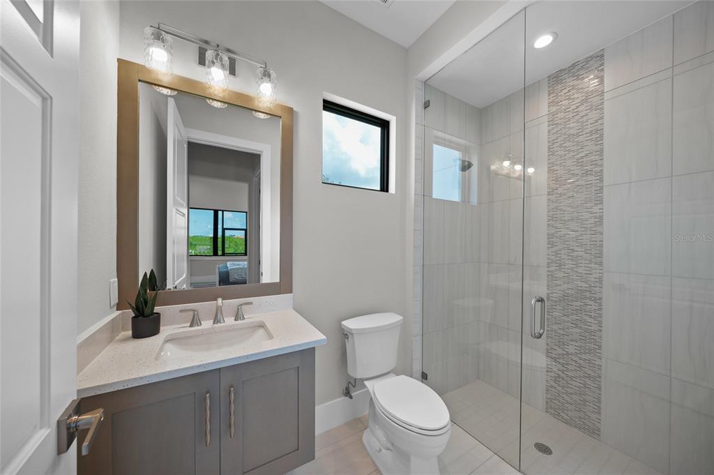 1109 Bayshore Road Nokomis, FL 34275 - Photo 31 of 63 a bathroom with a toilet a sink and mirror