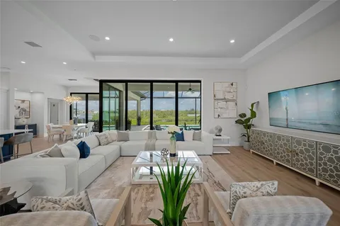 a living room with furniture floor to ceiling window and wooden floor