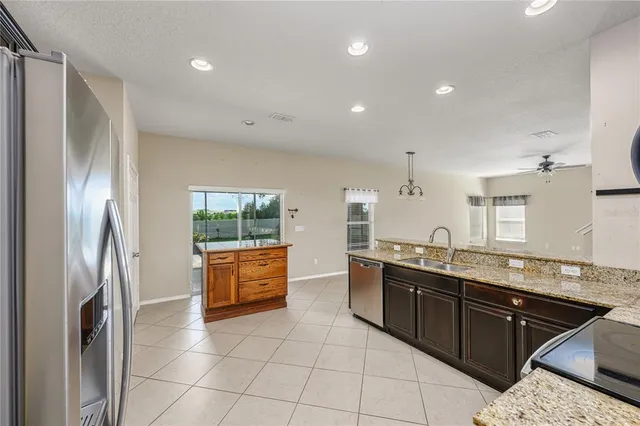 a large kitchen with stainless steel appliances granite countertop a refrigerator and a sink