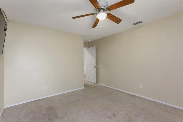 an empty room with a window and a fan