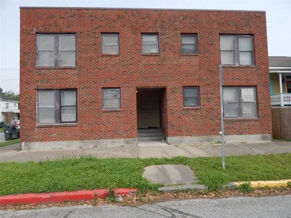 a brick house that has a lots of windows in it