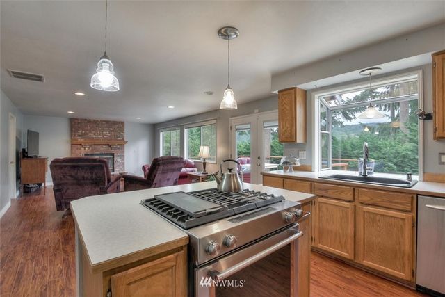 a kitchen with a stove a sink a counter space dining table and chairs