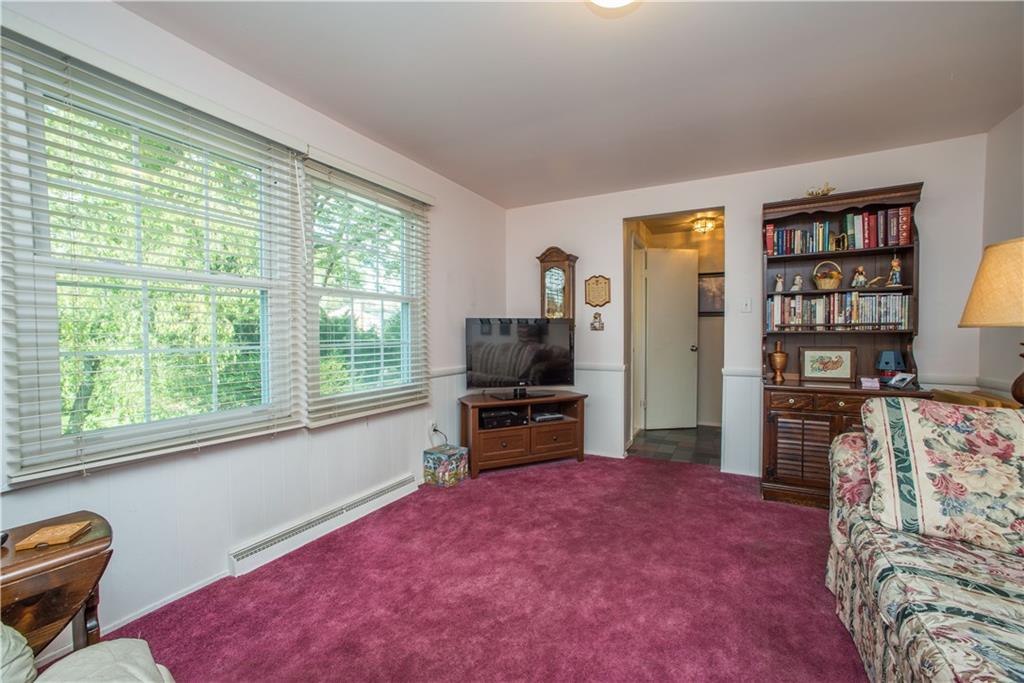 1484 Mayview Road Pittsburgh, PA 15241 - Photo 11 of 25 Hardwood flooring is found beneath the carpeting in the first floor family room. The double windows on the left, which face the rear of the home, could be swapped with sliding doors opening to a future deck.