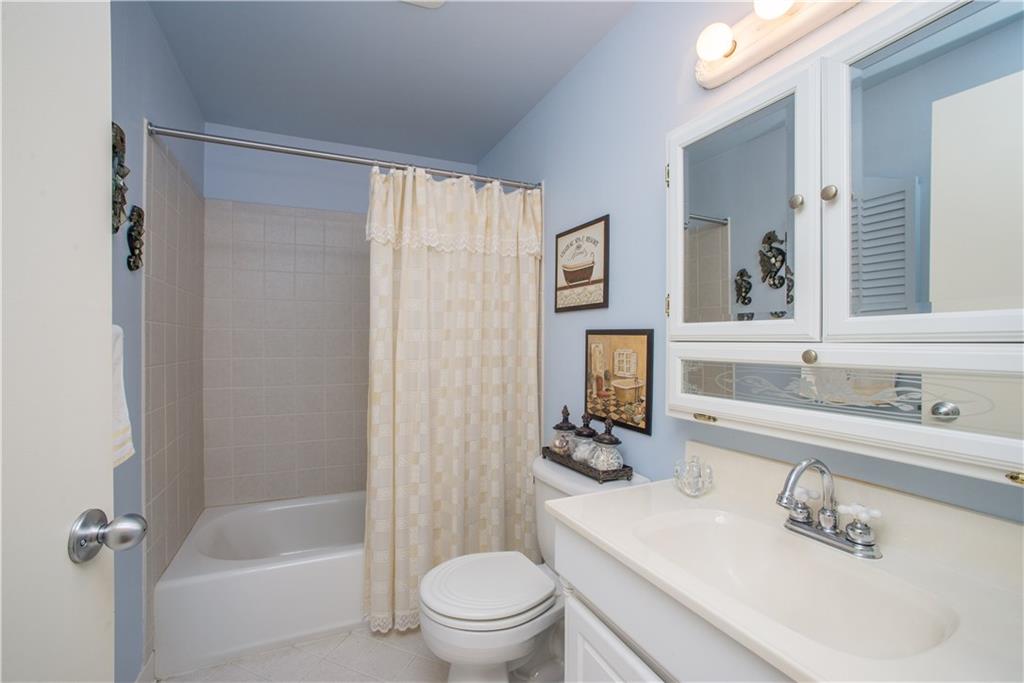 1484 Mayview Road Pittsburgh, PA 15241 - Photo 20 of 25 The updated main bath on the upper level has a combination tub and shower with tile surround, ceramic tile flooring, medicine cabinet with decorative glass doors, and vanity-style sink.