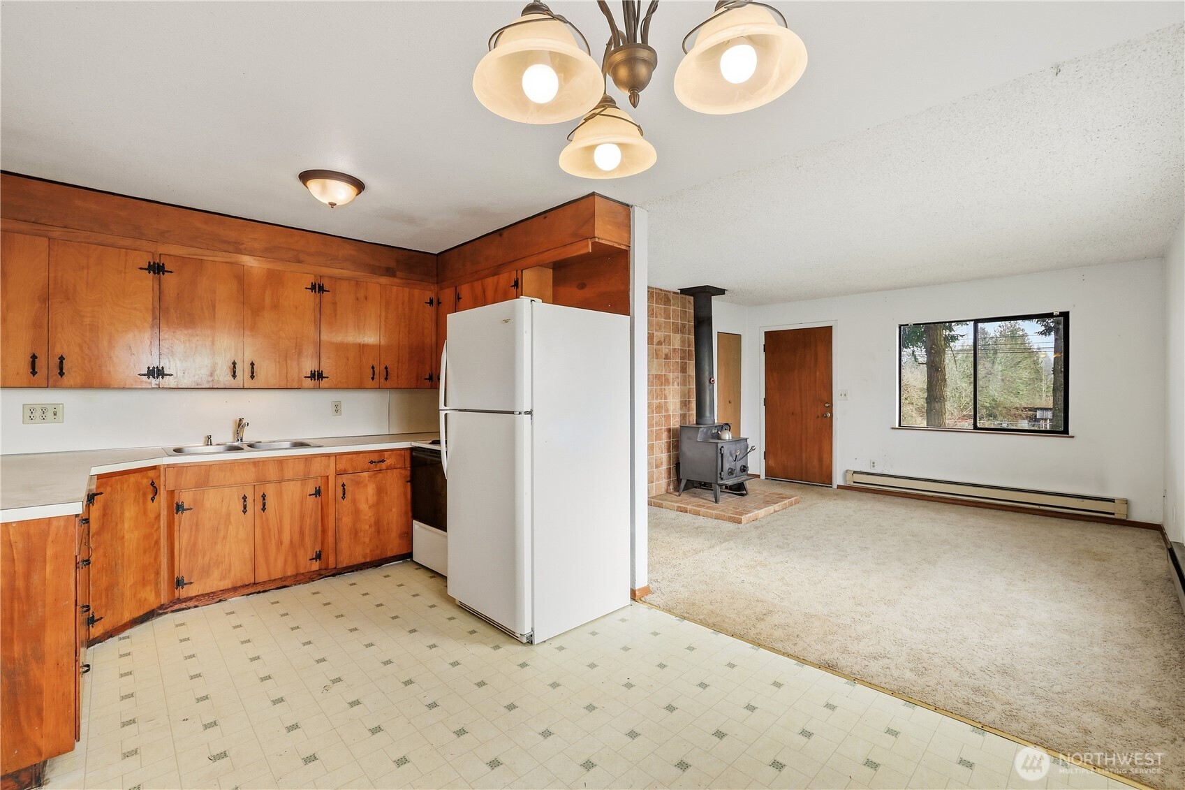 12204 Waller Road East Tacoma, WA 98446 - Photo 8 of 33 a kitchen with a refrigerator a stove top oven and cabinets