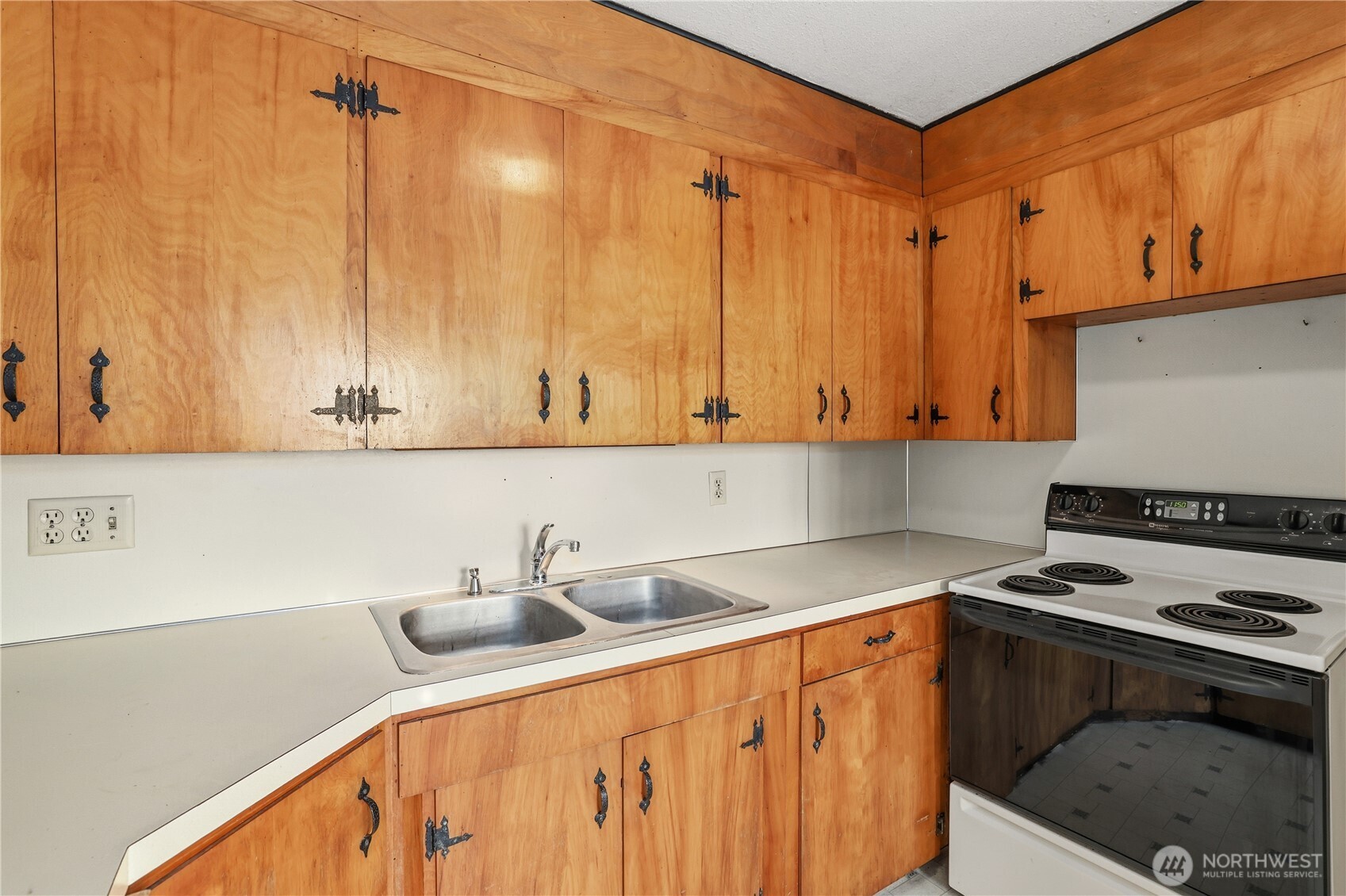 12204 Waller Road East Tacoma, WA 98446 - Photo 10 of 33 a kitchen with a sink a stove and cabinets