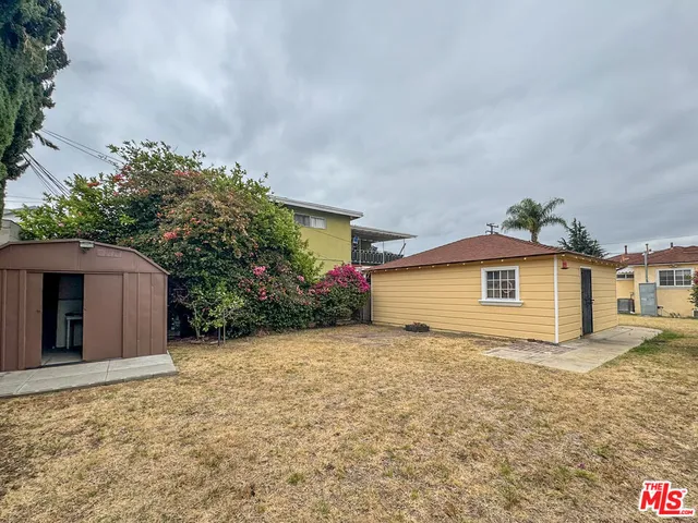 a view of a house with a yard and potted plants