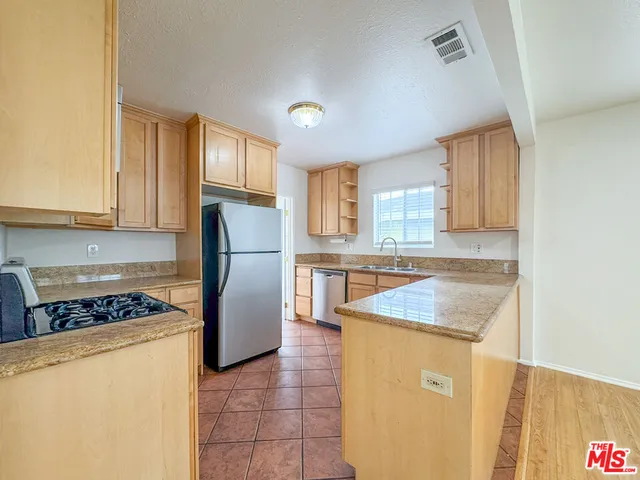 a kitchen with a refrigerator sink and cabinets