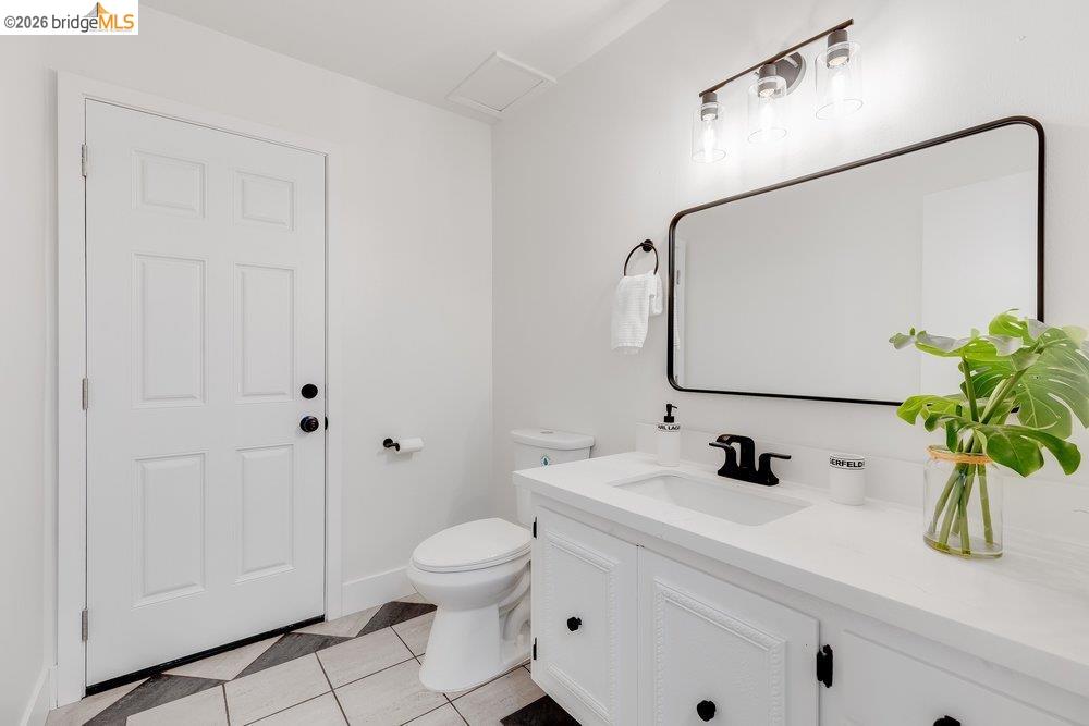 1298 Ribbon Street Foster City, CA 94404 - Photo 40 of 86 Modern bathroom featuring a white vanity with integrated sink, matte black hardware, and an overhead three-light fixture