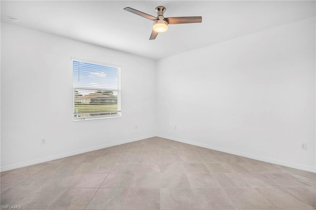 2265 Avocado Lane Naples, FL 34102 - Photo 12 of 32 an empty room with ceiling fan and window