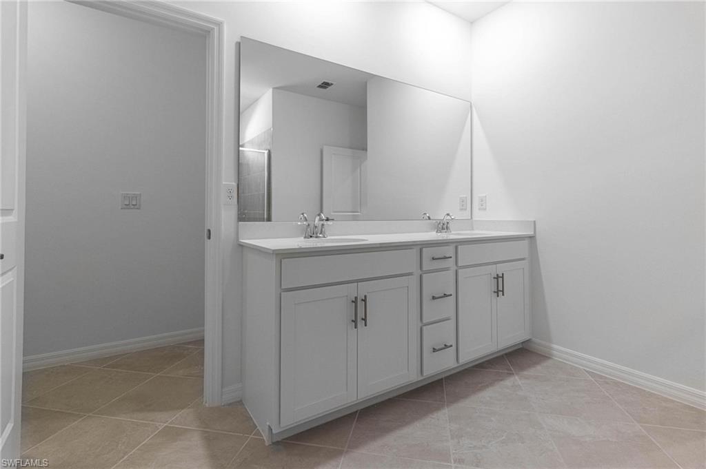 2265 Avocado Lane Naples, FL 34102 - Photo 14 of 32 a spacious bathroom with a double vanity sink and a mirror
