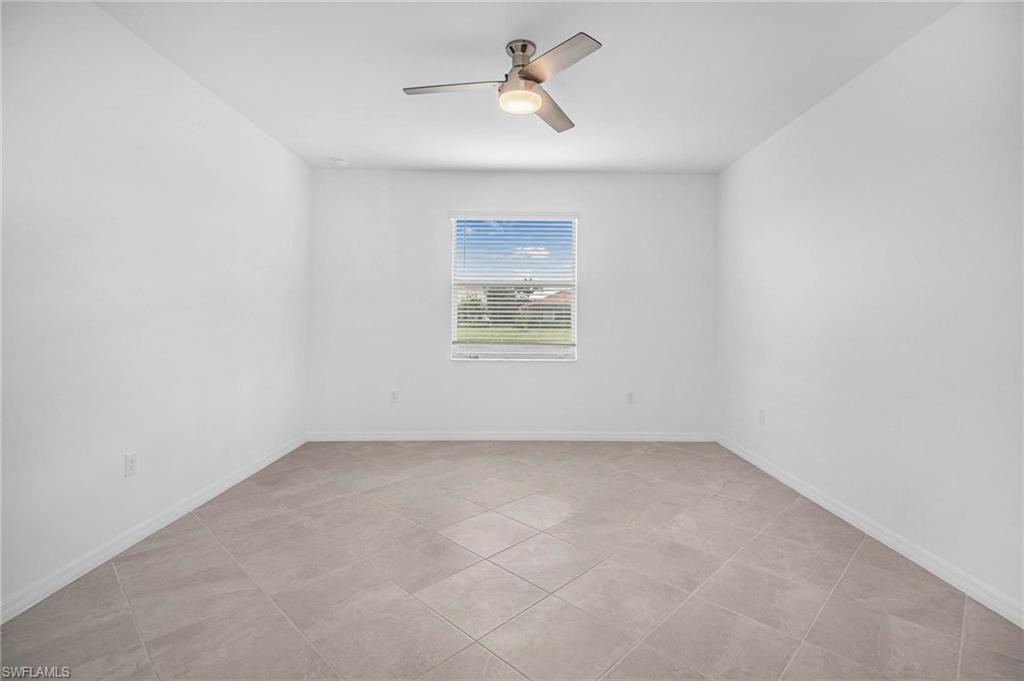 2265 Avocado Lane Naples, FL 34102 - Photo 18 of 32 an empty room with a window and a ceiling fan