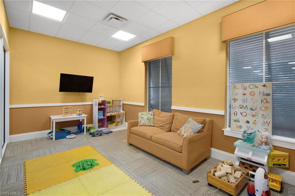 2265 Avocado Lane Naples, FL 34102 - Photo 25 of 32 a living room with furniture and a flat screen tv