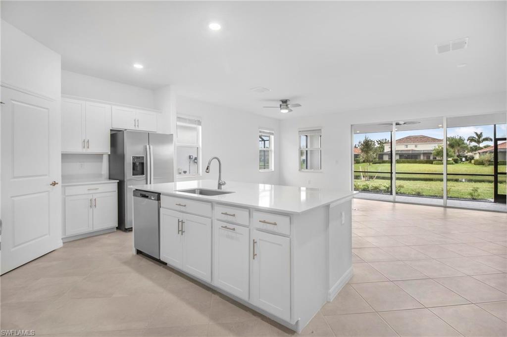 2265 Avocado Lane Naples, FL 34102 - Photo 5 of 32 a large kitchen with kitchen island a sink stainless steel appliances and cabinets