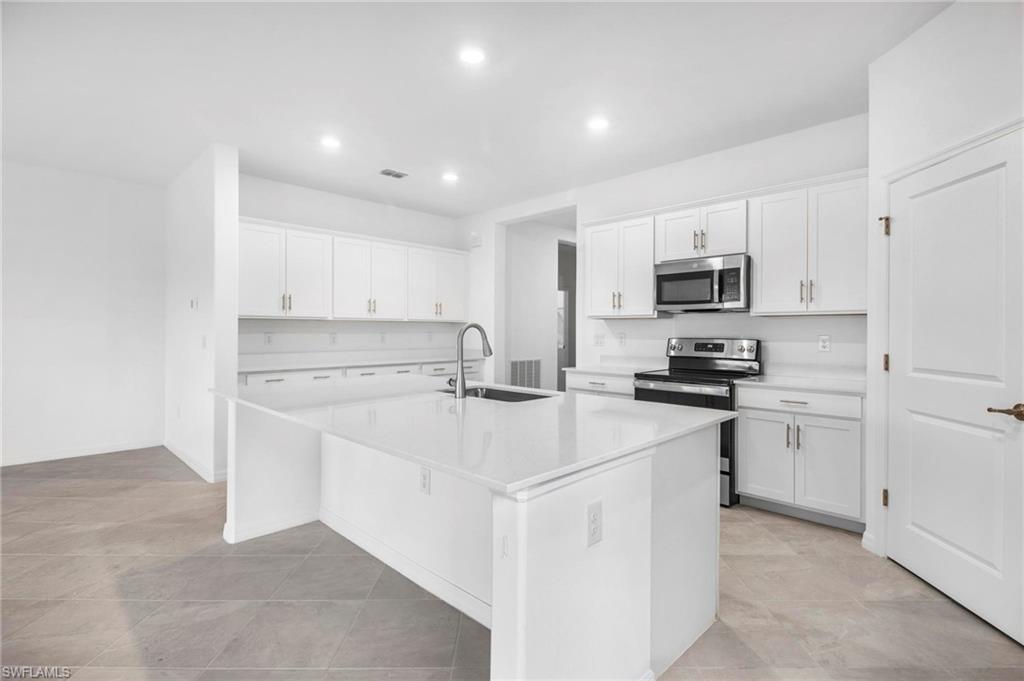 2265 Avocado Lane Naples, FL 34102 - Photo 7 of 32 a kitchen with appliances a sink and cabinets