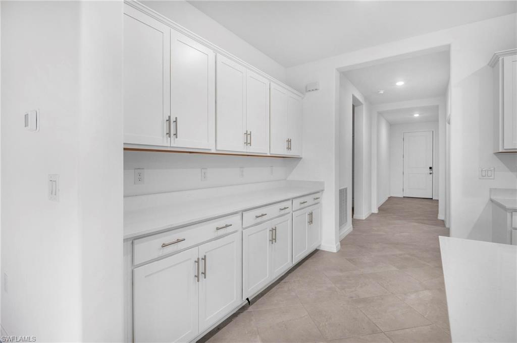 2265 Avocado Lane Naples, FL 34102 - Photo 8 of 32 a view of a kitchen with white cabinets