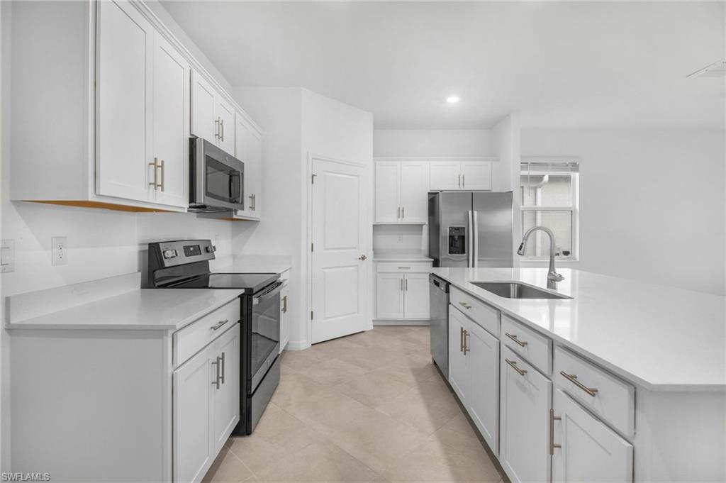 2265 Avocado Lane Naples, FL 34102 - Photo 9 of 32 a kitchen with granite countertop a sink and stainless steel appliances
