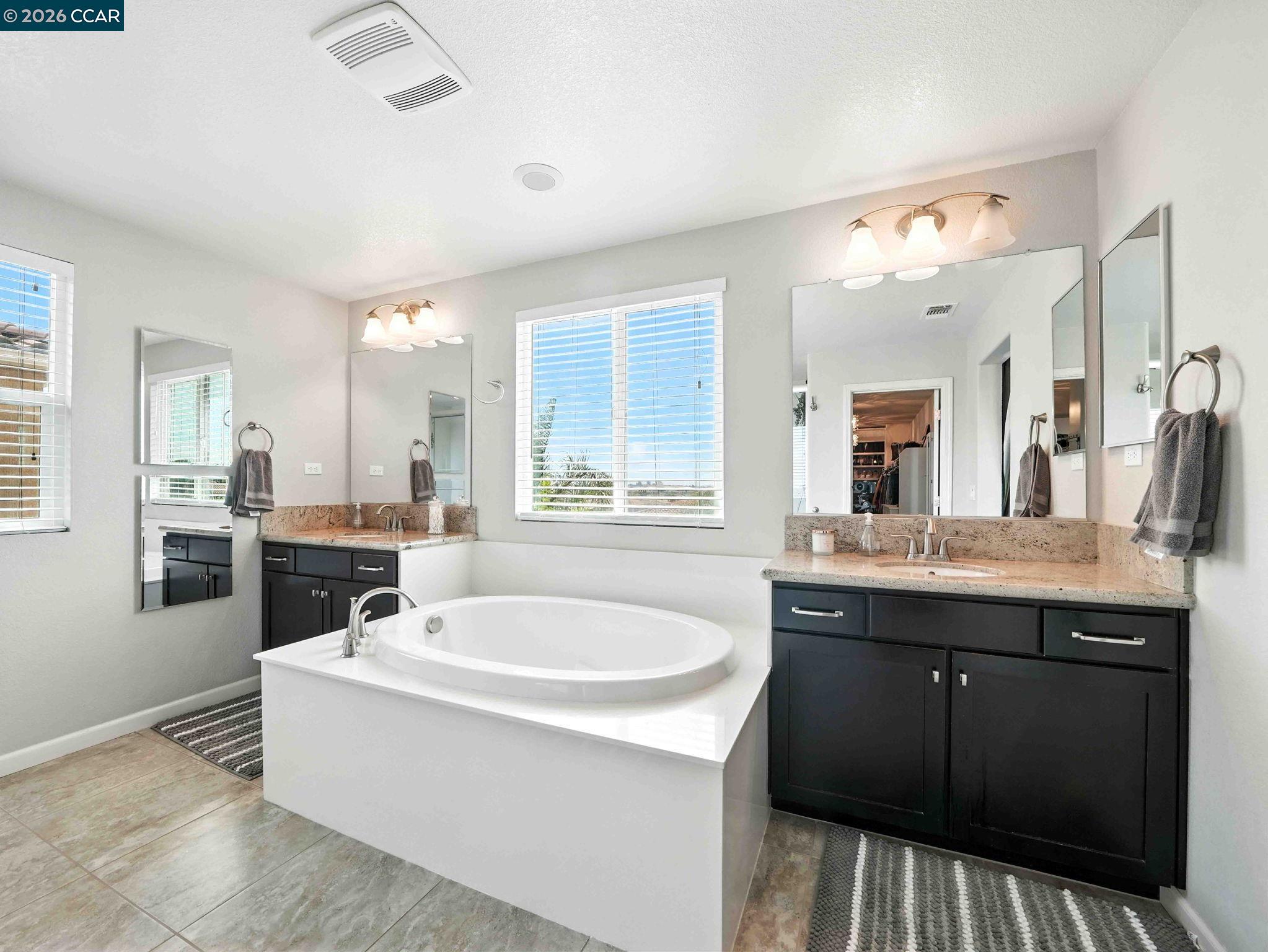 2433 Sanders Lane Fairfield, CA 94533 - Photo 33 of 51 a spacious bathroom with a tub double sink and mirror