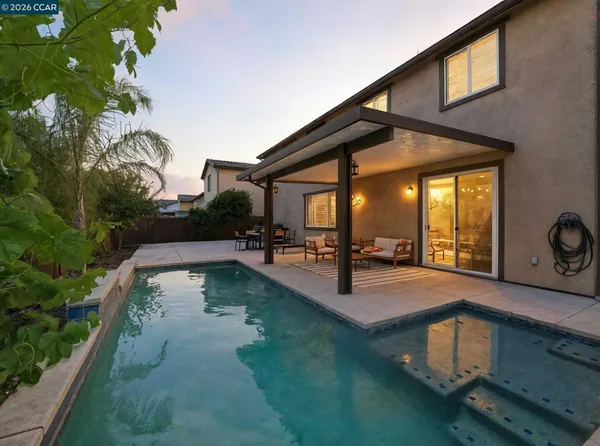 a kitchen with stainless steel appliances granite countertop a dining table chairs refrigerator and microwave