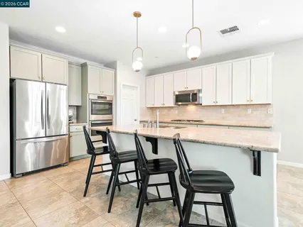 a kitchen with a table chairs and white cabinets