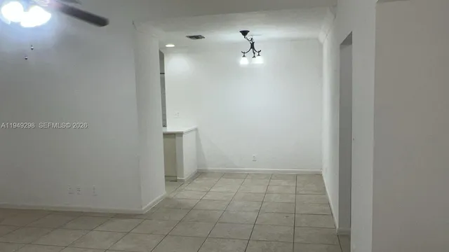 an empty room with closet and a chandelier fan