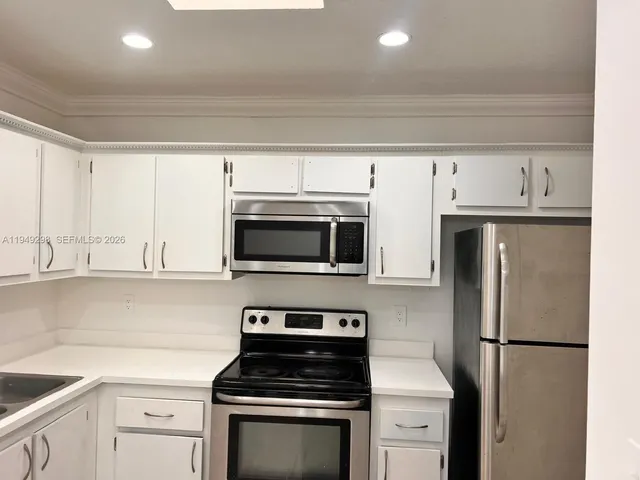 a kitchen with cabinets stainless steel appliances and a sink