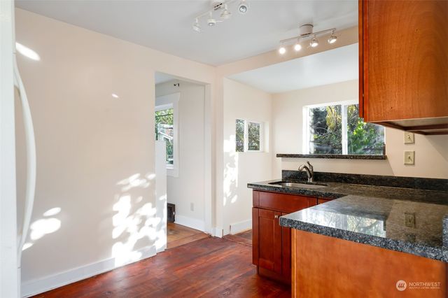 a kitchen with granite countertop a sink a counter top space and cabinets