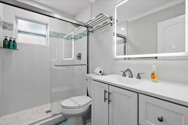 a bathroom with a sink a toilet and shower