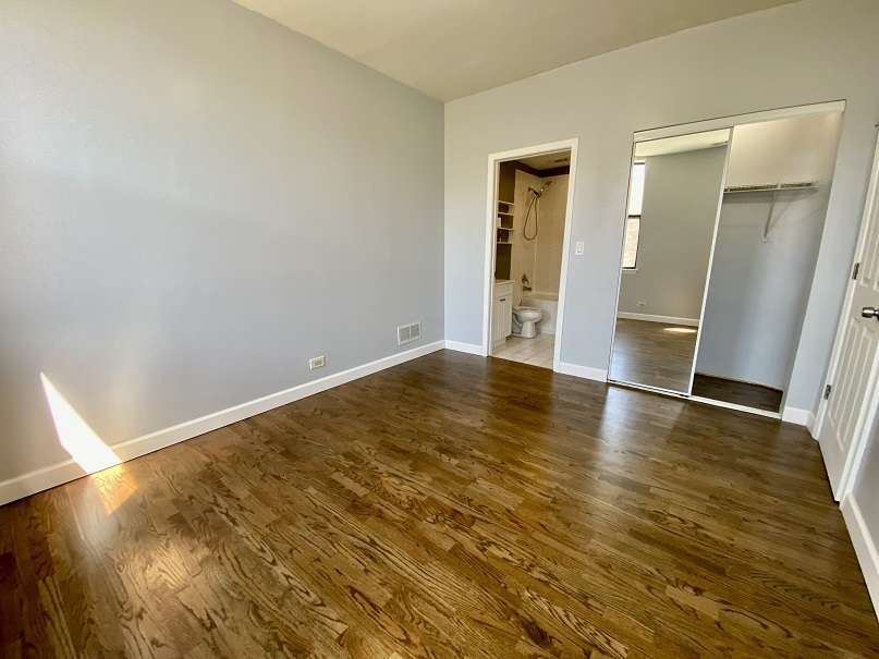 3131 South Benson Street, Unit 10 Chicago, IL 60608 - Photo 11 of 17 an empty room with wooden floor and closet