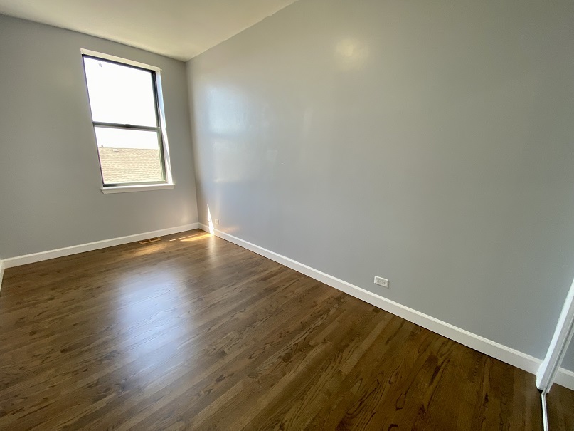 3131 South Benson Street, Unit 10 Chicago, IL 60608 - Photo 13 of 17 a view of an empty room with wooden floor and a window