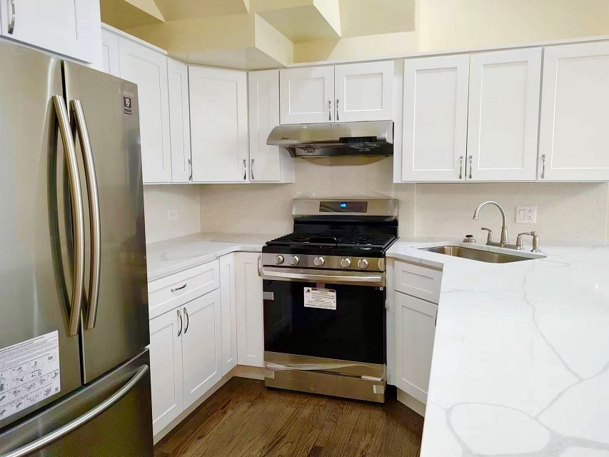 3131 South Benson Street, Unit 10 Chicago, IL 60608 - Photo 6 of 17 a kitchen with stainless steel appliances a refrigerator sink and white cabinets