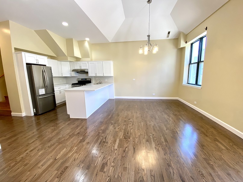 3131 South Benson Street, Unit 10 Chicago, IL 60608 - Photo 7 of 17 a kitchen with stainless steel appliances a refrigerator a sink dishwasher a stove and white countertops with wooden floor