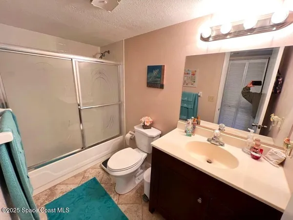 a bathroom with a sink a toilet a mirror and shower