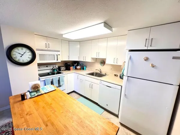 a kitchen with stainless steel appliances granite countertop a refrigerator sink stove and white cabinets