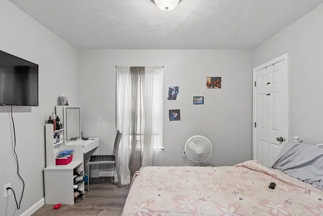 a bedroom with a bed and a flat tv screen on the dresser