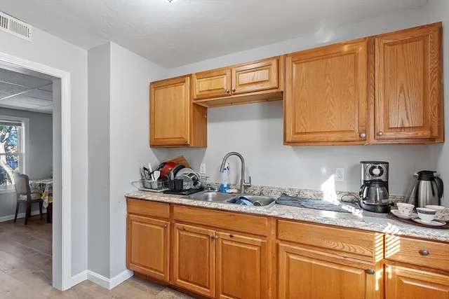 a kitchen with stainless steel appliances granite countertop a sink dishwasher cabinets and granite countertops with wooden floor