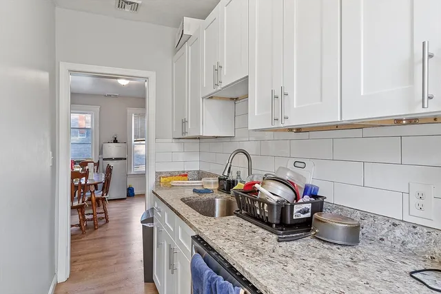 a kitchen with stainless steel appliances a dining table and chairs